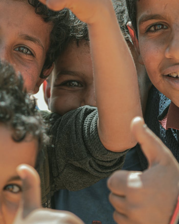 Smiling children in Syria expressing happiness with thumbs up gestures, vibrant and joyful.